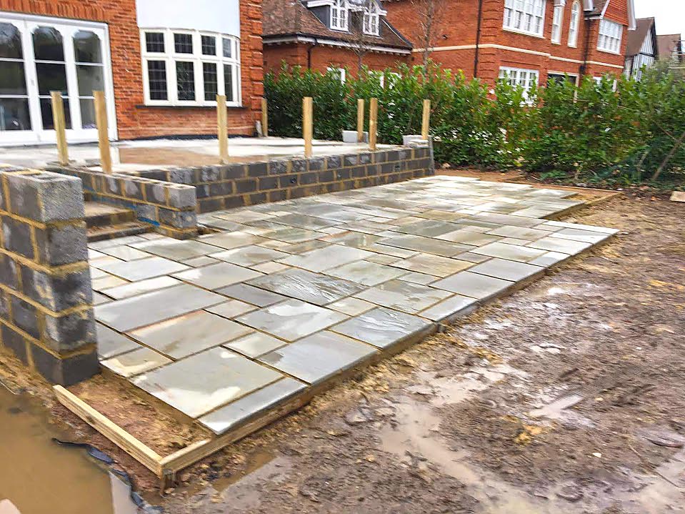 Two level rear patio showing the start of laying new stone paving